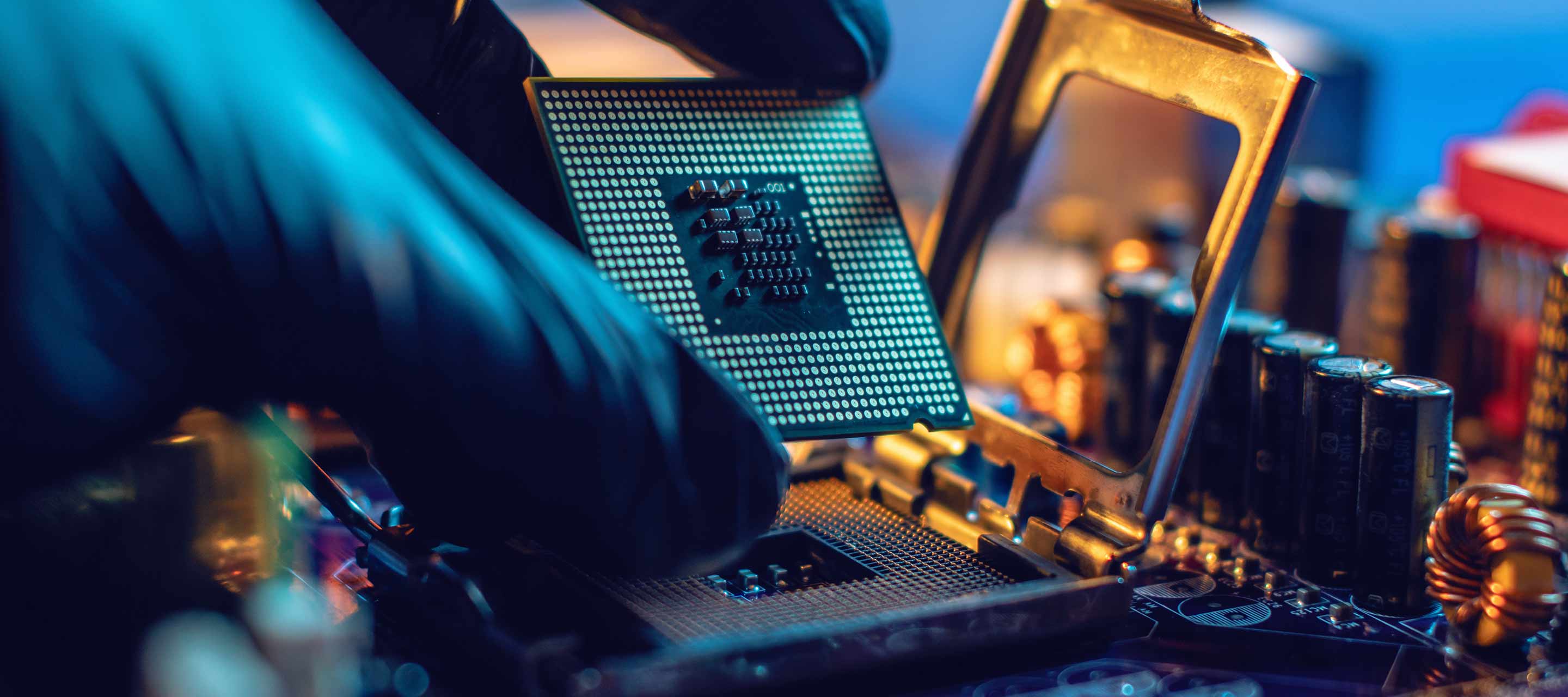 Engineer repairman holding hands CPU to insert into the socket of the motherboard. Technology hardware in the neon light