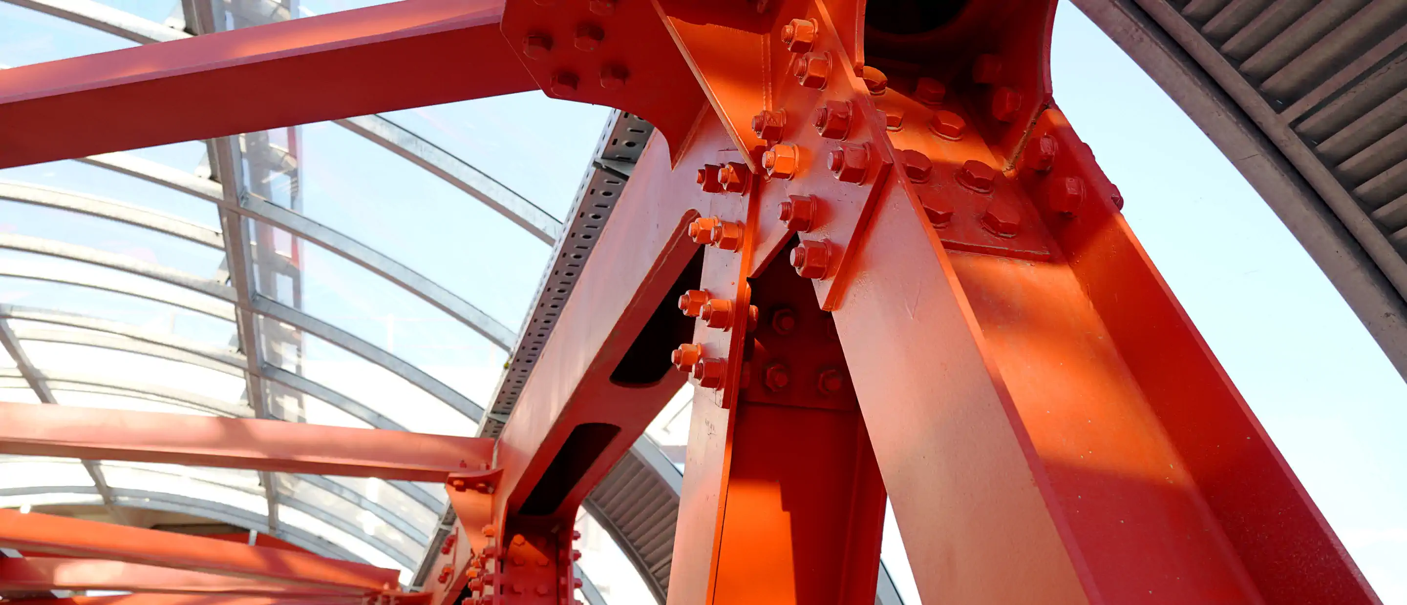 Red iron beams bolted on. Angular connection of several iron beams in one place. Pedestrian crossing with iron construction and ceiling.